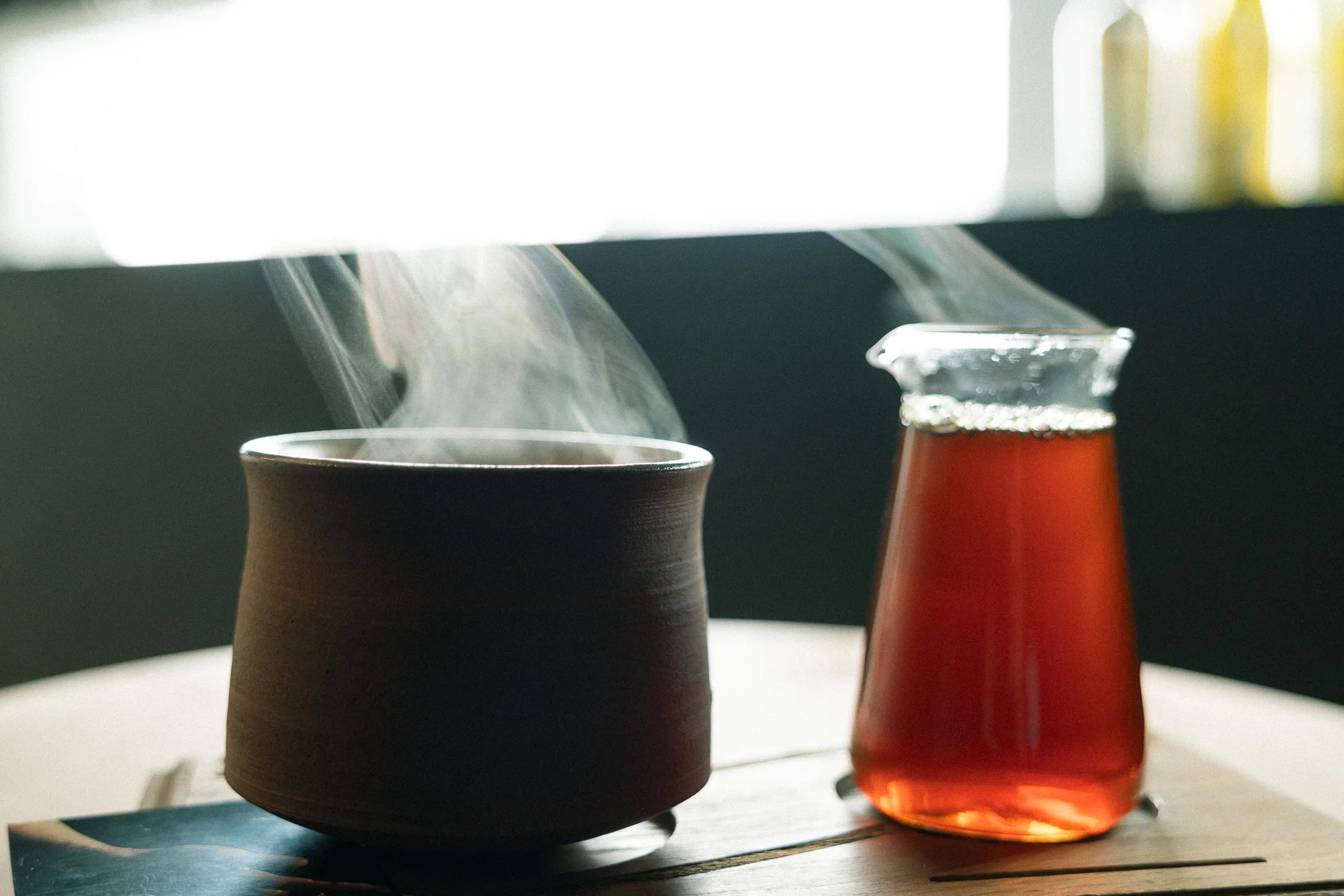 湯気の立つ陶器のカップと、ガラスサーバーに注がれたコーヒー
