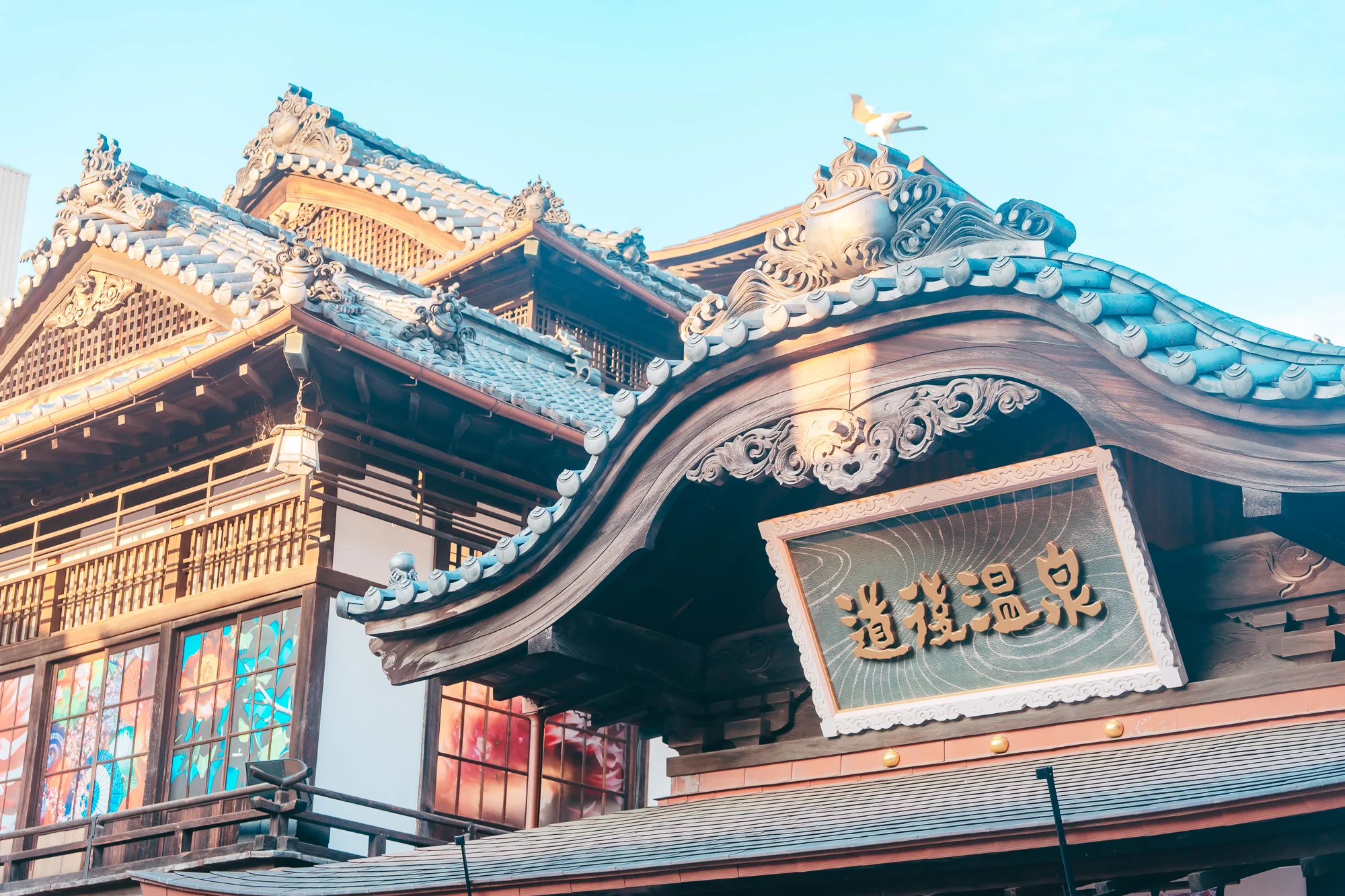 夕方の道後温泉本館の唐破風と看板